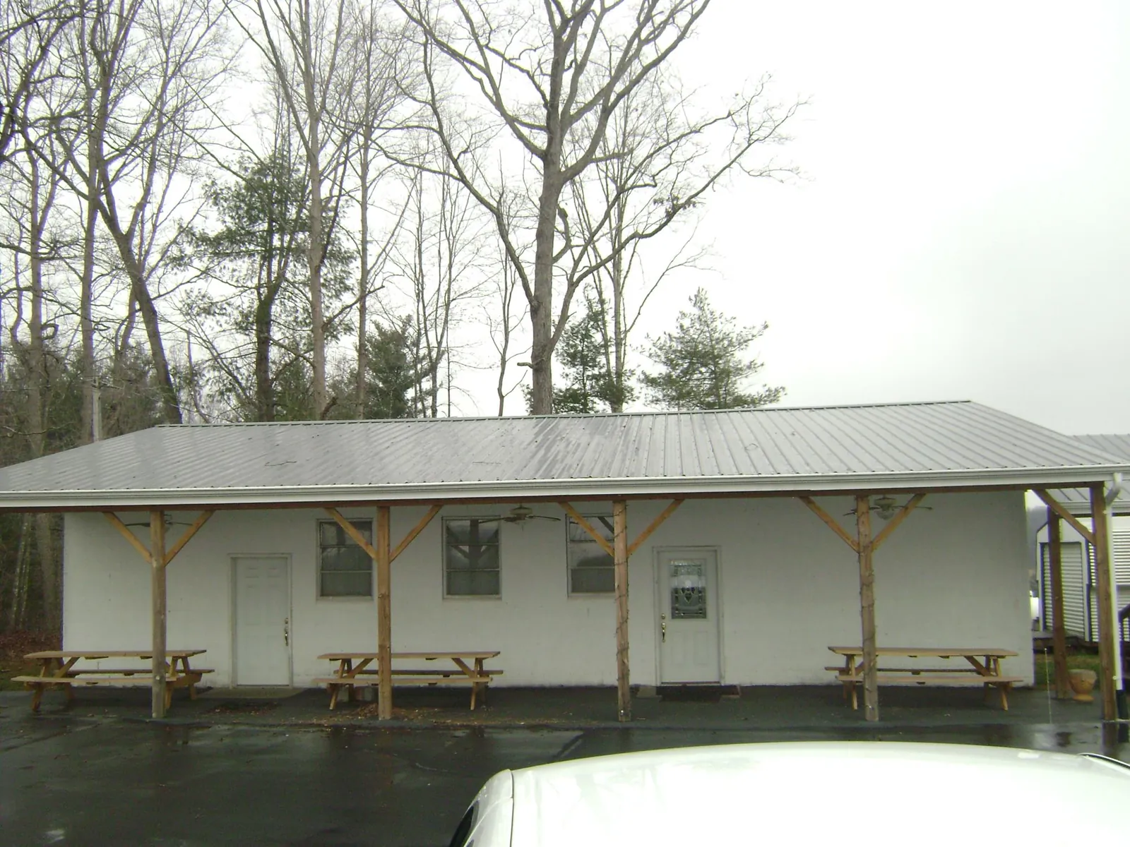Gray metal roof over a block building with a timber post porch in Oxford